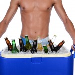 Closeup of a fit young man carrying an ice chest full of beer. M